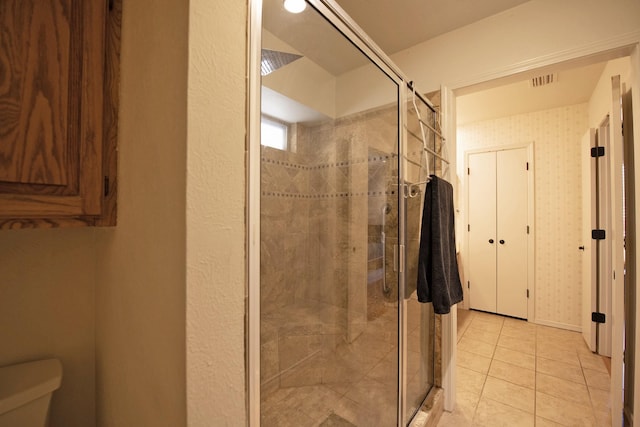 bathroom featuring tile patterned floors, visible vents, toilet, and a stall shower