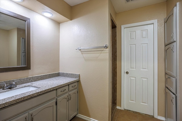 full bath with vanity, baseboards, and tile patterned floors