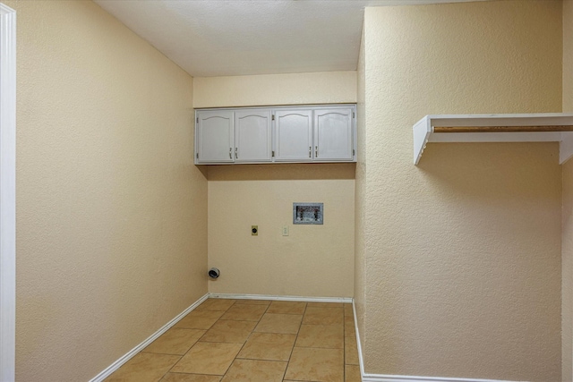 clothes washing area featuring washer hookup, light tile patterned floors, cabinet space, hookup for an electric dryer, and baseboards