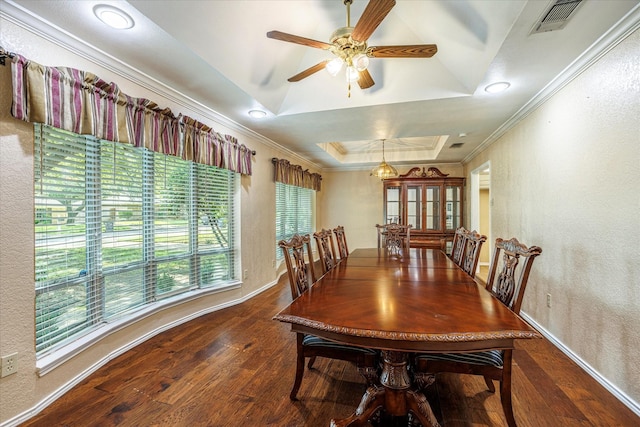 dining room with a textured wall, dark wood-type flooring, visible vents, ornamental molding, and a raised ceiling