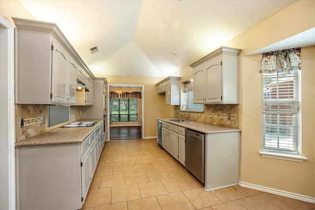 kitchen with lofted ceiling, under cabinet range hood, a sink, light countertops, and appliances with stainless steel finishes