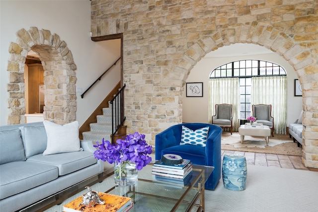 living room with arched walkways and stairway