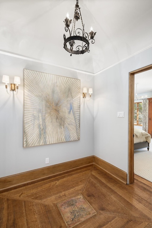 interior space featuring baseboards and a chandelier