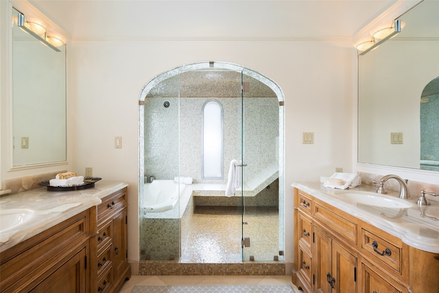 bathroom with a stall shower, two vanities, tile patterned floors, a sink, and a bath