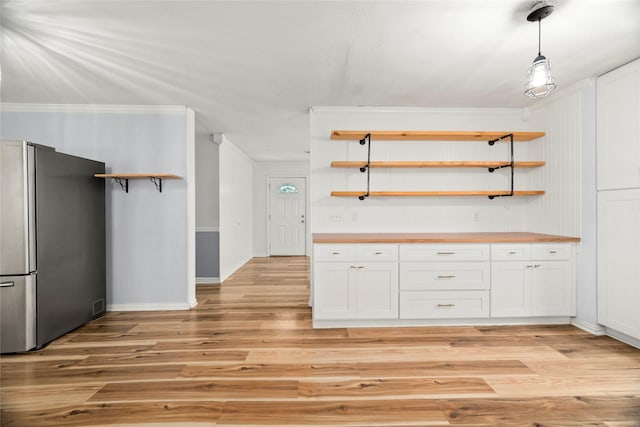 kitchen featuring open shelves, hanging light fixtures, freestanding refrigerator, and white cabinets