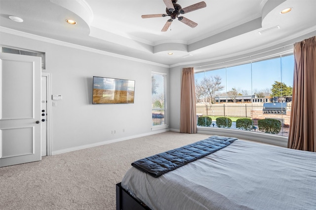 carpeted bedroom featuring a tray ceiling, crown molding, recessed lighting, a ceiling fan, and baseboards