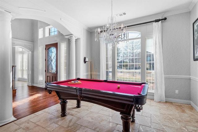 game room with decorative columns, stone tile floors, visible vents, arched walkways, and crown molding