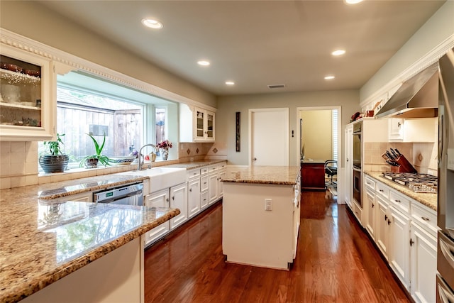 kitchen featuring glass insert cabinets, white cabinets, a kitchen island, and light stone counters