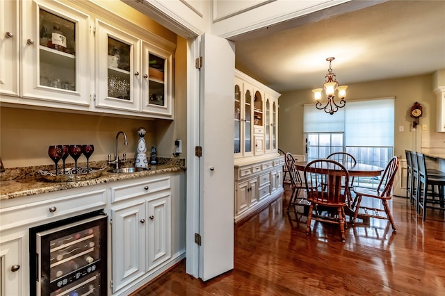 interior space with beverage cooler, a chandelier, and dark wood-style flooring