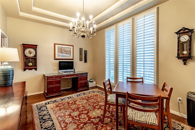 dining area with baseboards, an inviting chandelier, a raised ceiling, and a healthy amount of sunlight