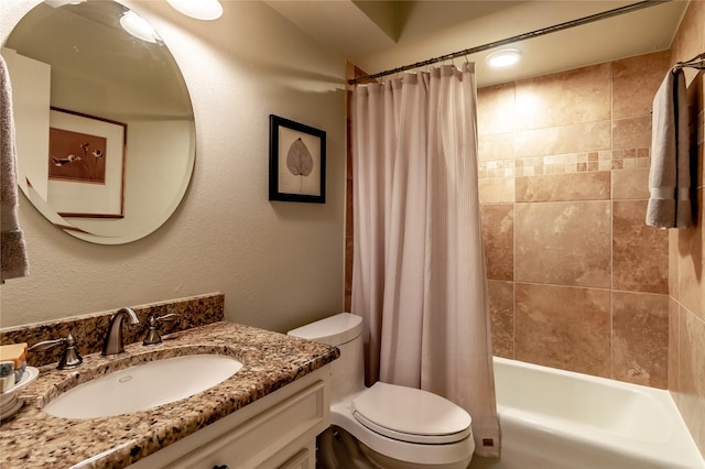 full bath with toilet, a textured wall, vanity, and shower / tub combo with curtain