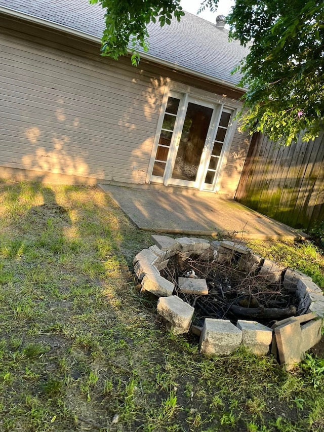 back of house featuring fence and roof with shingles