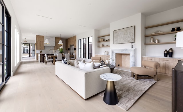 living area with a high end fireplace and light wood finished floors