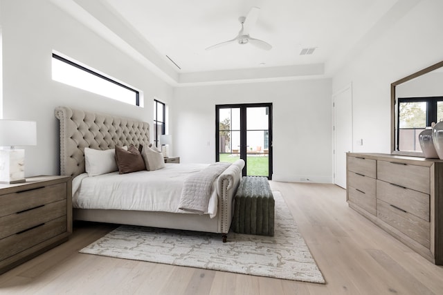 bedroom featuring light wood-style floors, visible vents, multiple windows, and access to exterior
