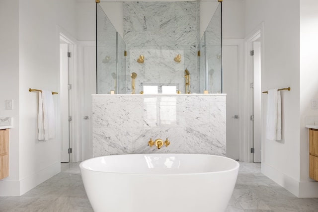 full bath with marble finish floor, a freestanding tub, vanity, and a marble finish shower