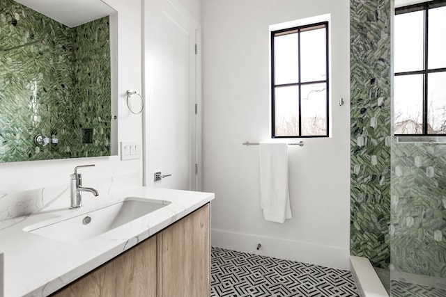 bathroom featuring tiled shower and vanity