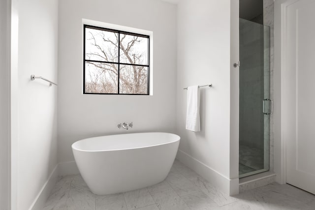 full bath featuring a freestanding bath, baseboards, a stall shower, and marble finish floor