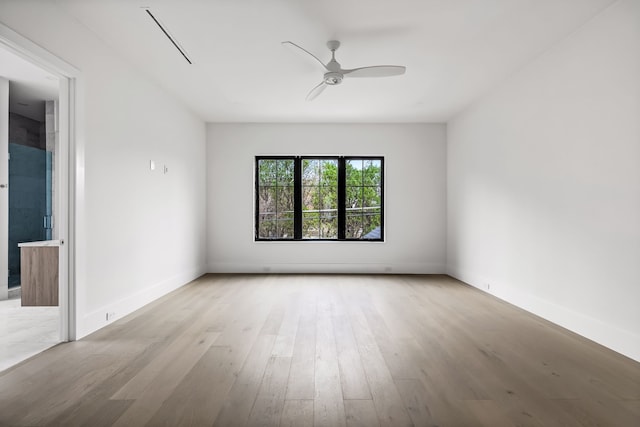 empty room with light wood-type flooring, ceiling fan, and baseboards