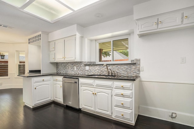 kitchen featuring a peninsula, baseboards, and dark countertops