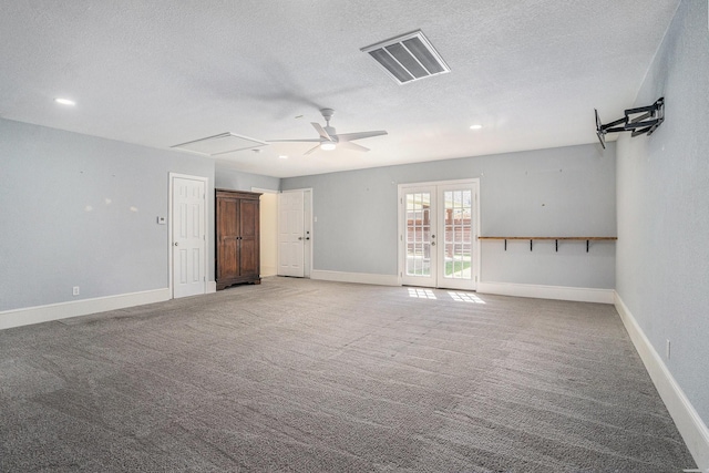 empty room featuring visible vents, a ceiling fan, a textured ceiling, attic access, and light carpet