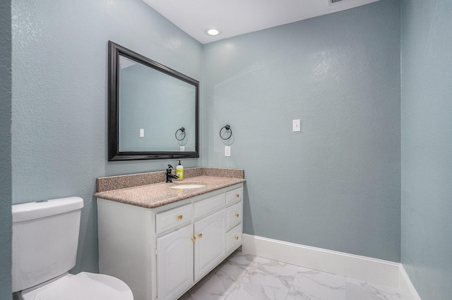 bathroom with vanity, marble finish floor, baseboards, and toilet