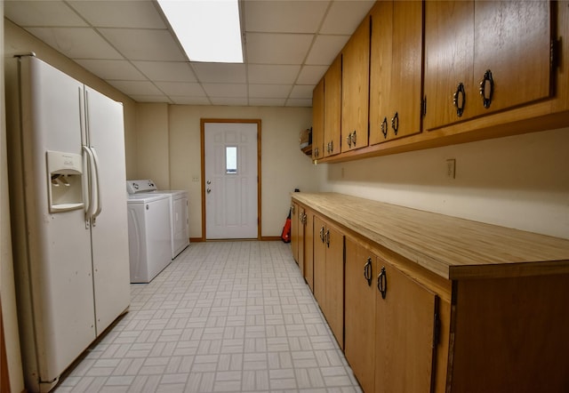 washroom featuring separate washer and dryer, cabinet space, and baseboards