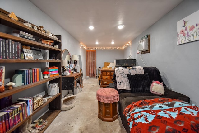 bedroom with a wall mounted AC and unfinished concrete floors