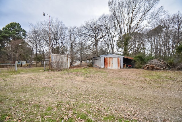 view of yard featuring a garage, fence, and an outdoor structure