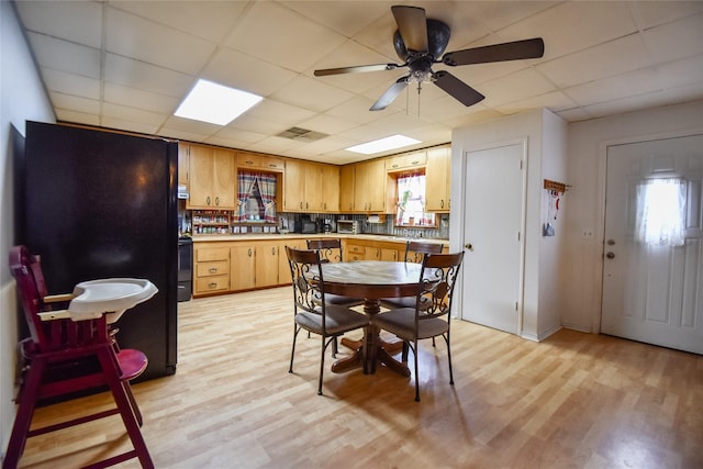 dining space featuring ceiling fan, a paneled ceiling, and light wood-style flooring