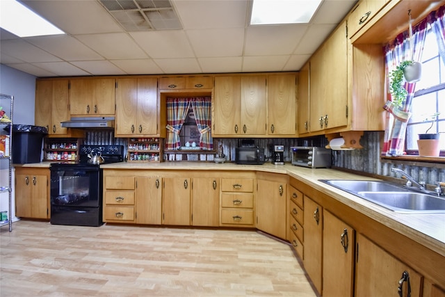 kitchen featuring a sink, black appliances, light countertops, and under cabinet range hood