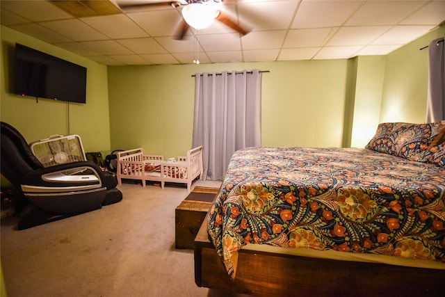 bedroom featuring a drop ceiling, carpet, and a ceiling fan