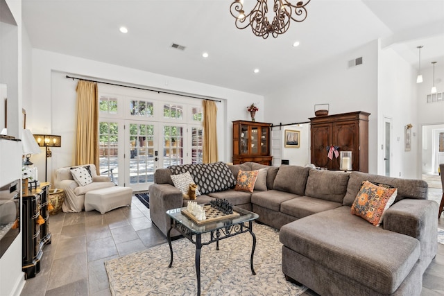 living area with high vaulted ceiling, a notable chandelier, a fireplace, visible vents, and french doors