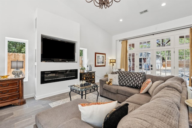 living room with baseboards, visible vents, a glass covered fireplace, french doors, and recessed lighting