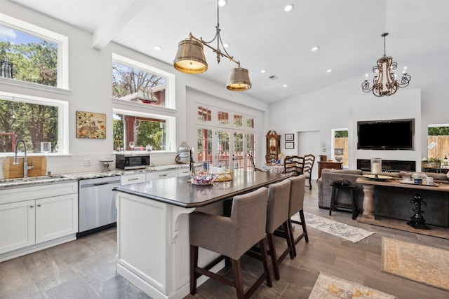 kitchen featuring stainless steel appliances, a sink, white cabinetry, and pendant lighting