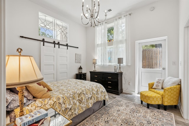 bedroom featuring a chandelier, visible vents, and a barn door