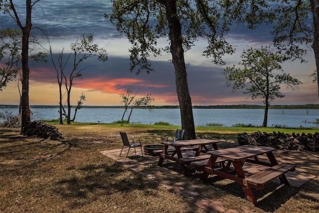 view of property's community featuring a water view and a fire pit