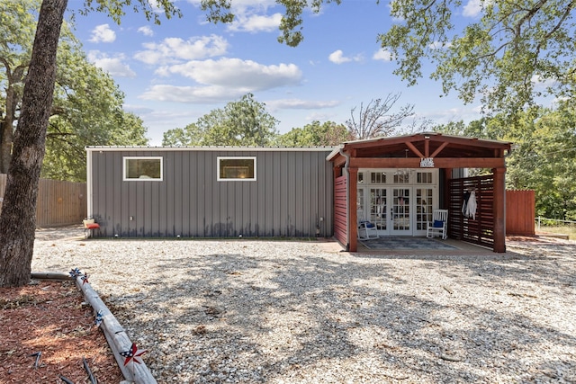 view of outbuilding with fence and french doors