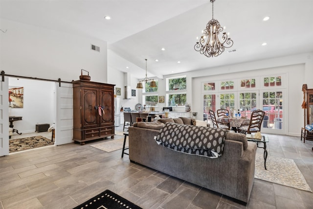 living room with high vaulted ceiling, recessed lighting, visible vents, and a barn door