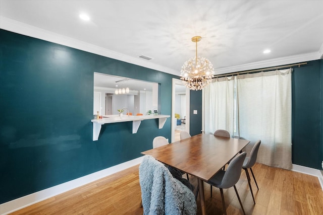 dining area featuring visible vents, baseboards, crown molding, light wood-type flooring, and a notable chandelier