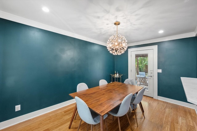 dining area with a notable chandelier, crown molding, recessed lighting, light wood-type flooring, and baseboards