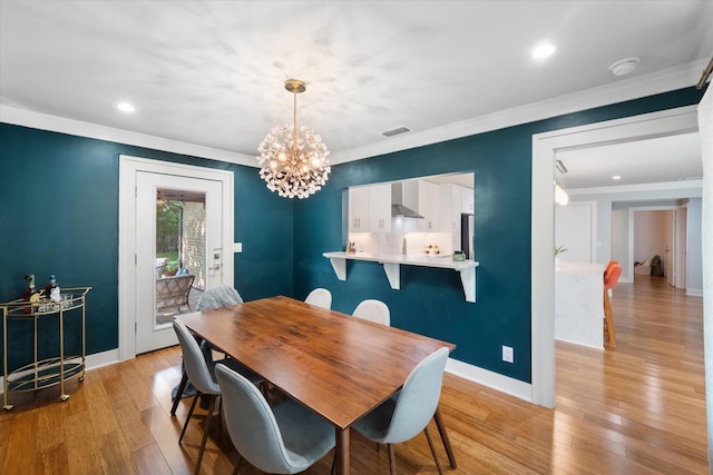 dining space with light wood-style floors, visible vents, and ornamental molding