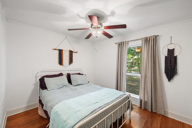 bedroom featuring crown molding, baseboards, and wood finished floors