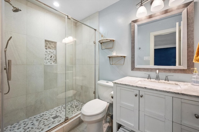 full bathroom with toilet, a shower stall, and vanity