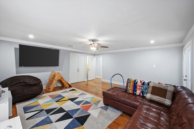 living area featuring light wood-style flooring, visible vents, baseboards, and crown molding