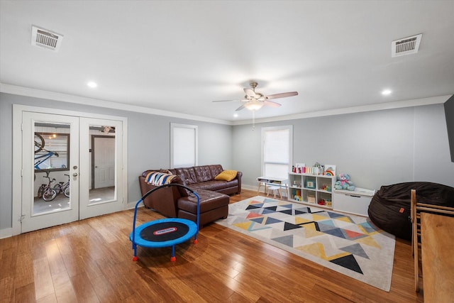 playroom with french doors, visible vents, crown molding, and wood finished floors