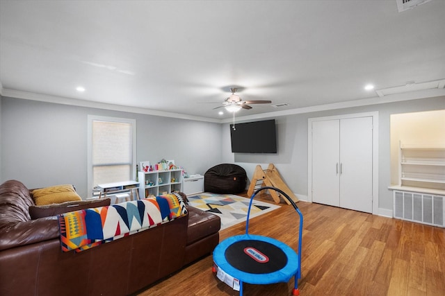 living room featuring recessed lighting, light wood-type flooring, visible vents, and crown molding