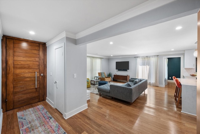 living area with light wood-style floors, recessed lighting, and ornamental molding