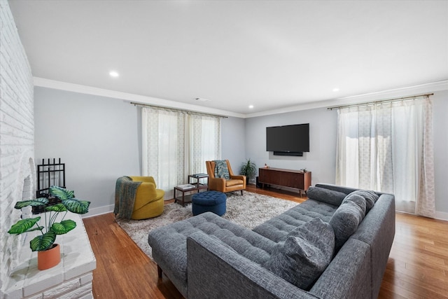 living room featuring baseboards, ornamental molding, and wood finished floors