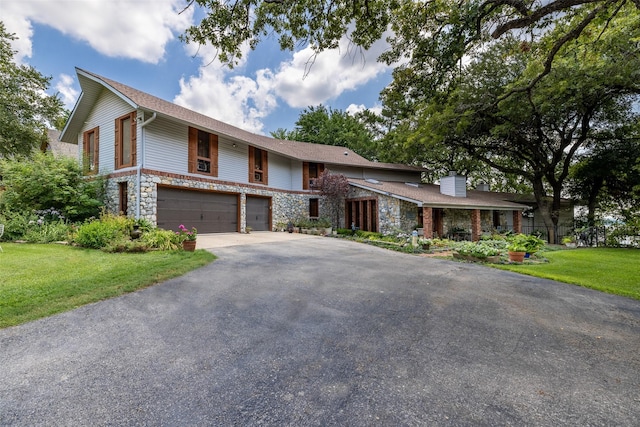 view of front facade featuring stone siding, aphalt driveway, an attached garage, and a front yard