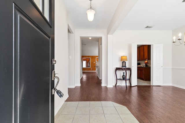 entrance foyer featuring a chandelier, baseboards, visible vents, and light wood finished floors